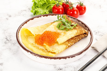 Russian pancake with red caviar and arugulaの写真素材