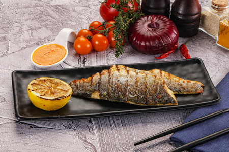 Grilled seabass fillet with lemon and sauceの写真素材