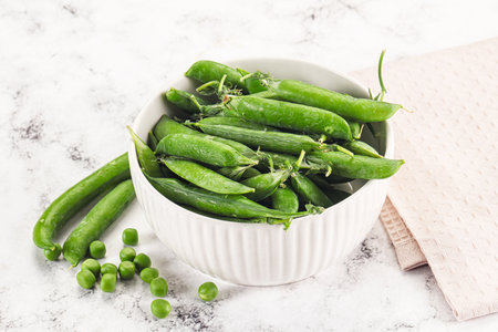 Sweet young green peas heap in the bowlの写真素材