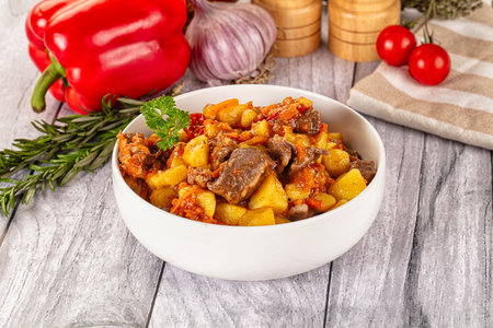 Potato stew with beef and vegetables in a bowl on wooden backgroundの写真素材