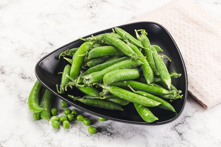 Sweet young green peas heap in the bowlの写真素材