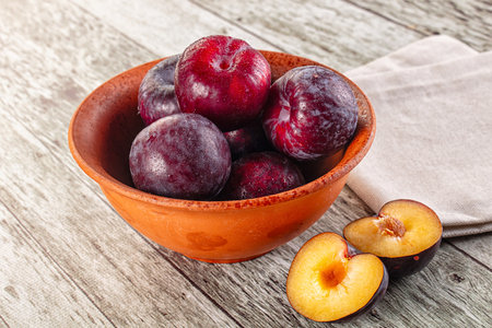 Ripe sweet juicy plum heap in the bowlの写真素材