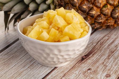 Sweet canned pineapple fruit pieces with syrupの写真素材