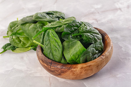 Raw green baby spinach plant in the bowl