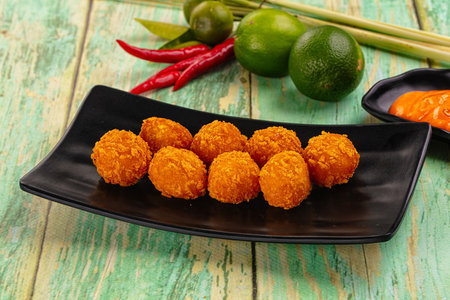 Fried crispy yellow cheese balls with sauce