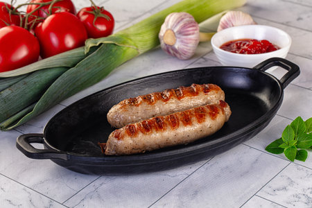 Grilled pork sausages served tomato sauce and vegetablesの写真素材