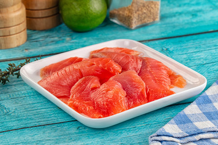 Delicous sliced salmon fillet ready to eat in the plate served thyme