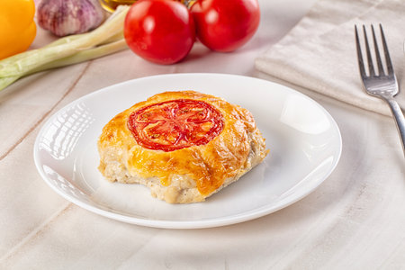 Chicken choplet baked with cheese and tomatoの写真素材