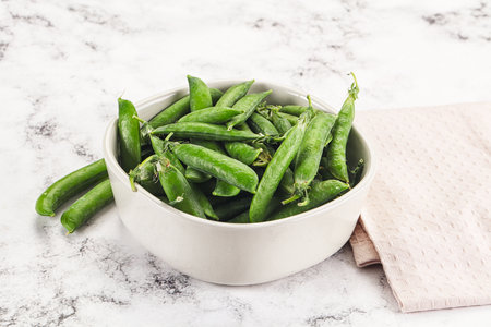 Sweet young green peas heap in the bowl