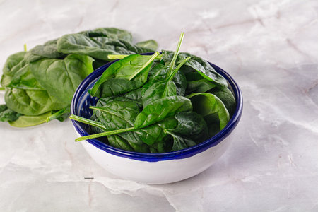 Raw green baby spinach plant in the bowl