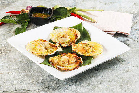 Griiled scallops in shell with cheese served sauce