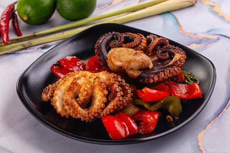 Gourmet grilled octopus with vegetables and sauceの写真素材