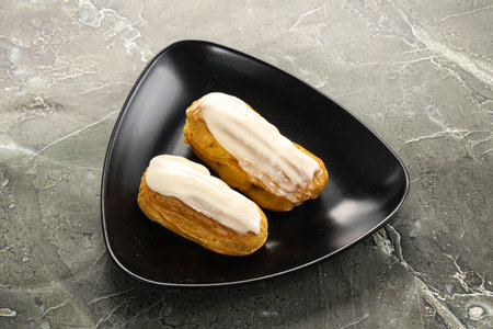 Delicious tasty eclair with ising and cream