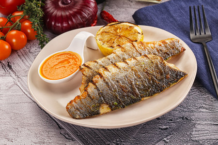 Grilled seabass fillet with lemon and sauceの写真素材