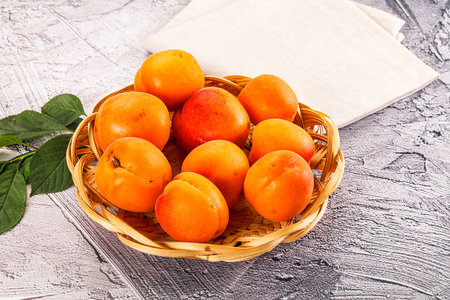 Raw ripe sweet apricots heap served leafの写真素材