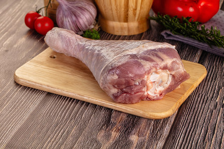 Raw turkey drumstick leg over board for cookingの写真素材