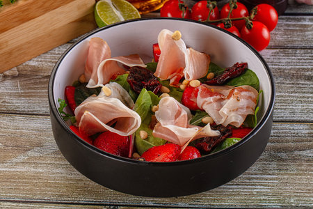 Salad with jamon, strawberry, dry tomato and arugulaの写真素材