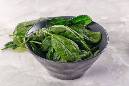 Raw green baby spinach plant in the bowl