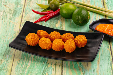 Fried crispy yellow cheese balls with sauce