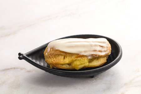 Delicious tasty eclair with icing and cream