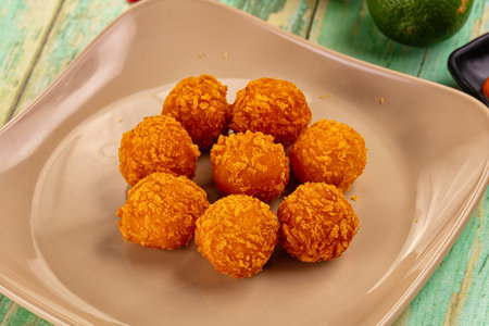 Fried crispy yellow cheese balls with sauce