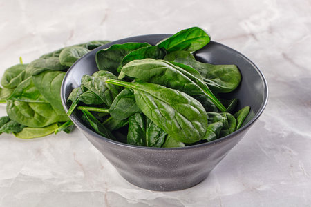 Raw green baby spinach plant in the bowl