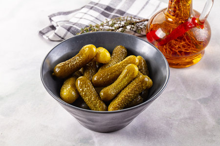 Marinated canned green cornichon cucumbers in the bowlの写真素材