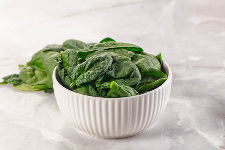 Raw green baby spinach plant in the bowlの写真素材