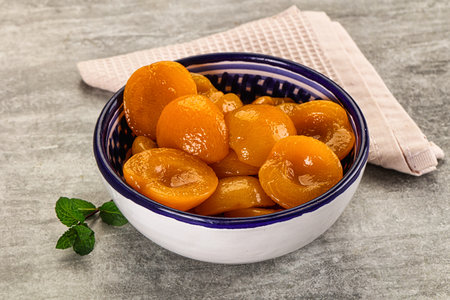 Sweet apricots with syrup in the bowlの写真素材