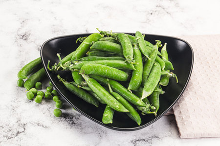 Sweet young green peas heap in the bowlの写真素材