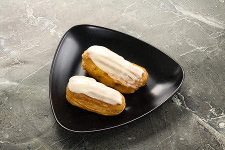 Delicious tasty eclair with icing and cream