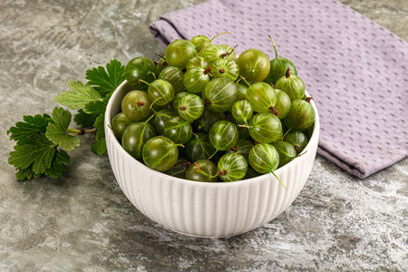 Ripe sweet and juicy gooseberry in the bowl with leafの写真素材