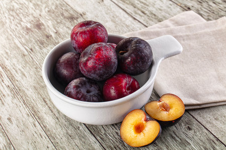 Ripe sweet juicy plum heap in the bowlの写真素材