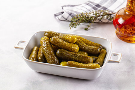 Marinated canned green cornichon cucumbers in the bowlの写真素材