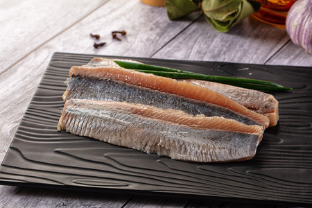 Marinated salted herring fillet slices in the plate