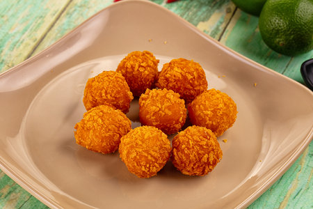 Fried crispy yellow cheese balls with sauce