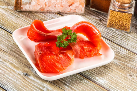 Salted sliced salmon fillet snack served Parsley