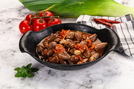 Baked chicken hearts with vegetables in sauce