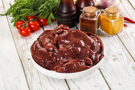 Raw chicken liver uncooked in the bowl with spicesの写真素材