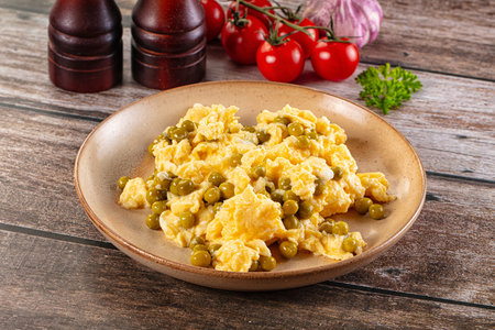 Scrambled egg omelet with green peas for breakfastの写真素材