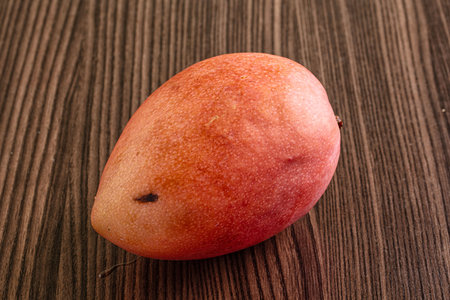 Whole ripe sweet tropical red mango fruitの写真素材
