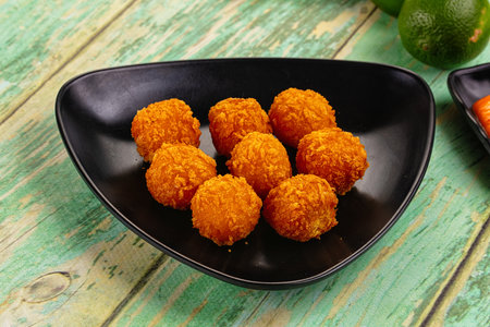 Fried crispy yellow cheese balls with sauce