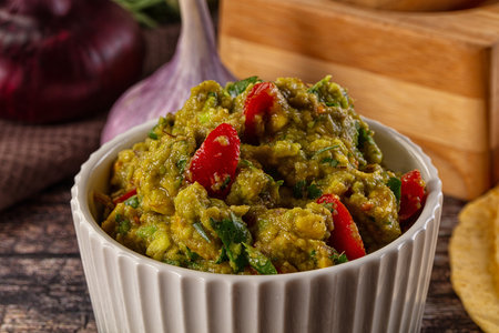 Green spicy Mexican guacamole dip in the bowl