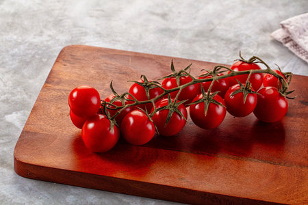 Ripe sweet cherry tomato branch over boardの写真素材