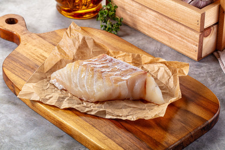Raw code fish fillet for cooking over board