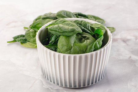 Raw green baby spinach plant in the bowl