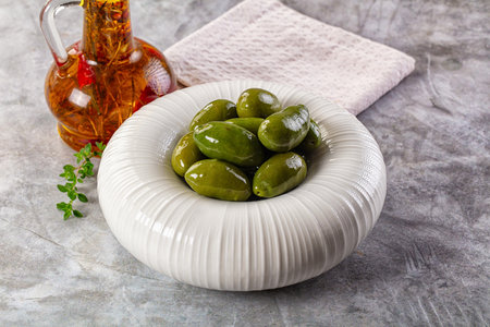 Marinated green organic Greek olives in the bowlの写真素材