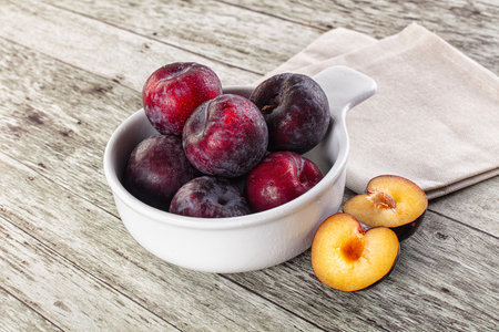 Ripe sweet juicy plum heap in the bowlの写真素材