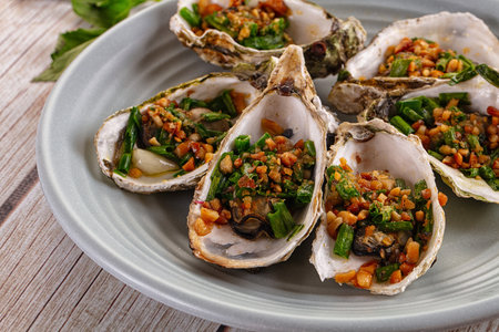 Grilled oysters with green onion and peanutの写真素材