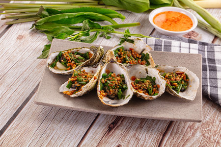 Grilled oysters with green onion and peanutの写真素材